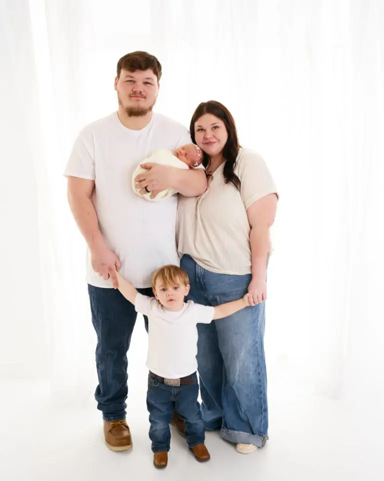 Family with newborn and toddler in front of a. window newborn photos delta ohio